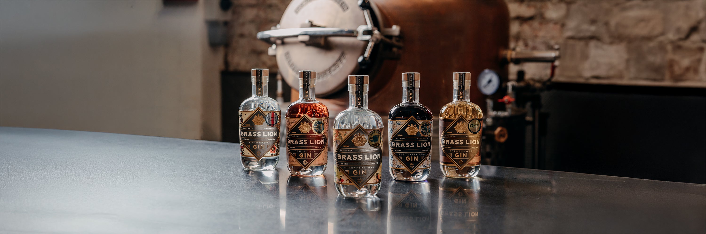 A lineup of Brass Lion Distillery’s signature gin bottles displayed in front of a copper still—used as the FAQ page banner to highlight the brand’s handcrafted Singapore spirits.