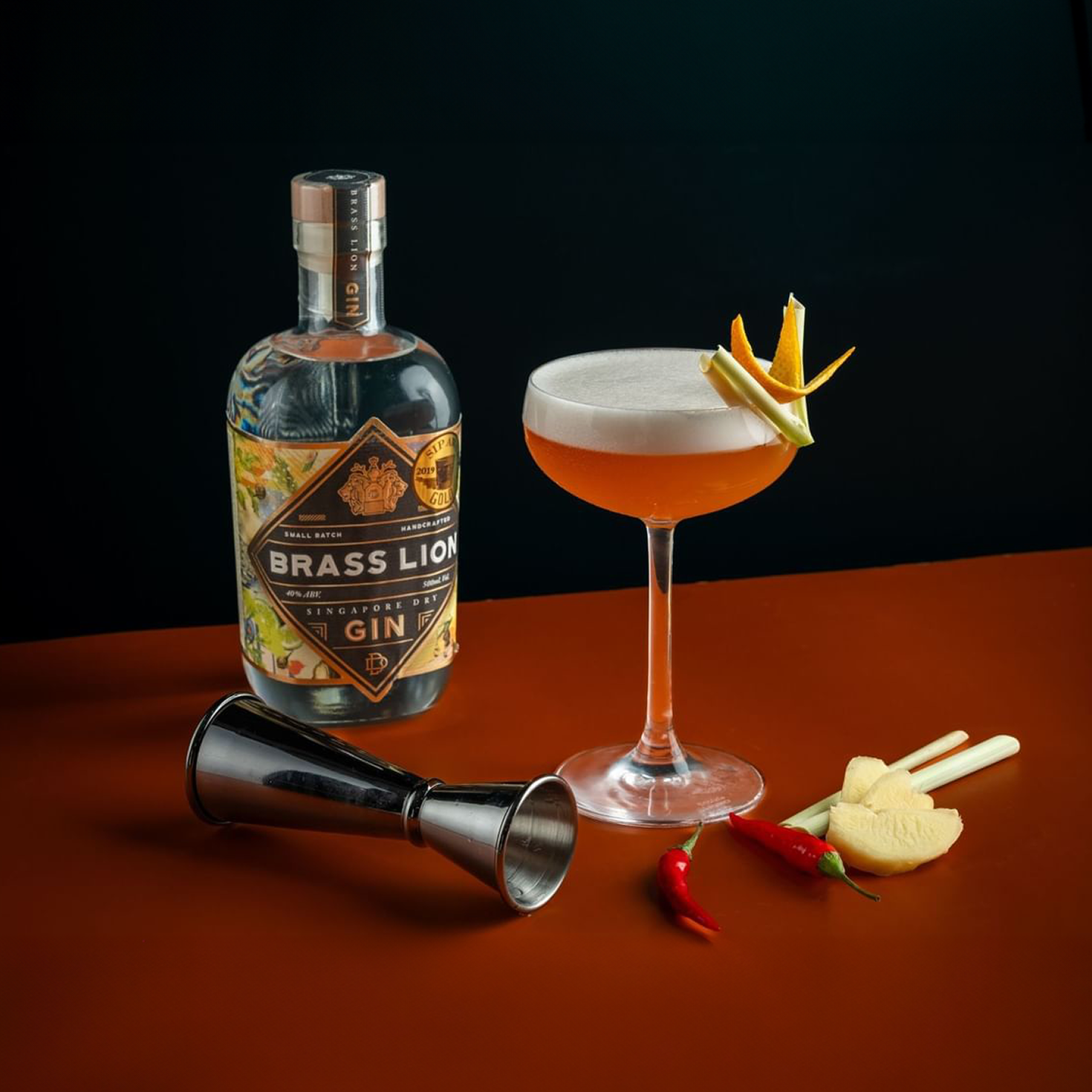 Brass Lion Singapore Dry Gin with a cocktail and fresh botanicals including chili, lemongrass and ginger